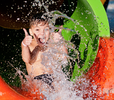 Boy on a waterslide showing thumbs up